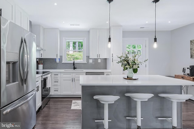 kitchen with stainless steel appliances, a sink, healthy amount of natural light, light countertops, and recessed lighting