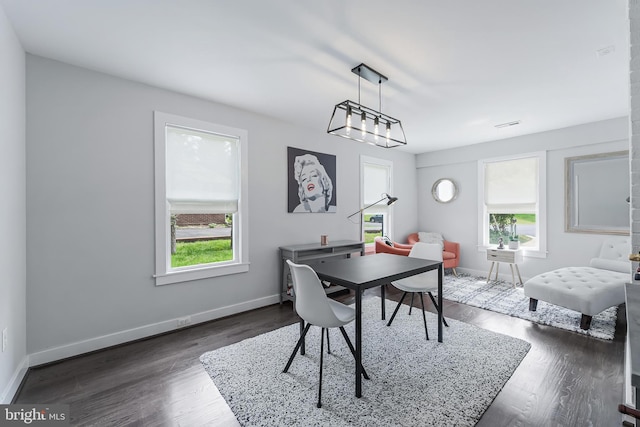 dining area with baseboards and dark wood finished floors