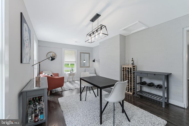 home office with wood finished floors, attic access, and baseboards