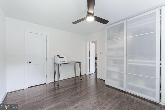 unfurnished bedroom with wood finished floors, baseboards, and a ceiling fan