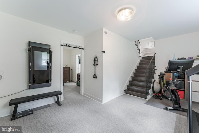 exercise area featuring carpet and baseboards