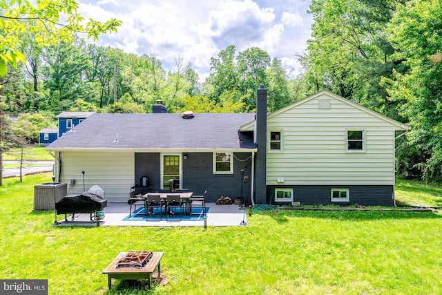 back of property with a patio, a chimney, a yard, and central AC unit