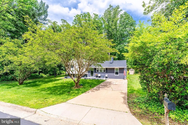 view of front of house with driveway and a front lawn