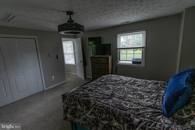 bedroom with baseboards, a textured ceiling, visible vents, and carpet floors