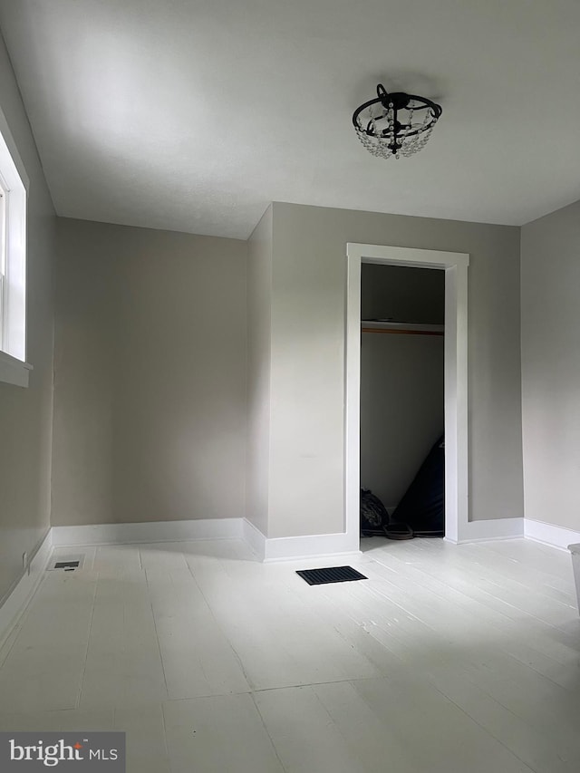 unfurnished bedroom with baseboards, a closet, and visible vents