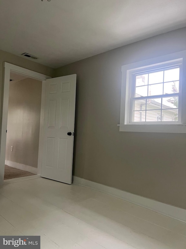 spare room with baseboards and visible vents