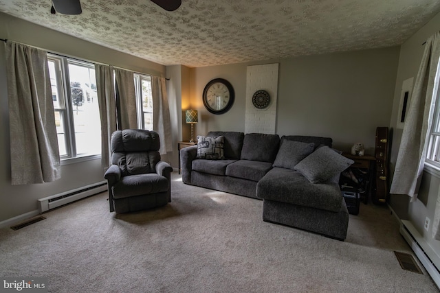 living area featuring carpet flooring, baseboard heating, ceiling fan, and visible vents