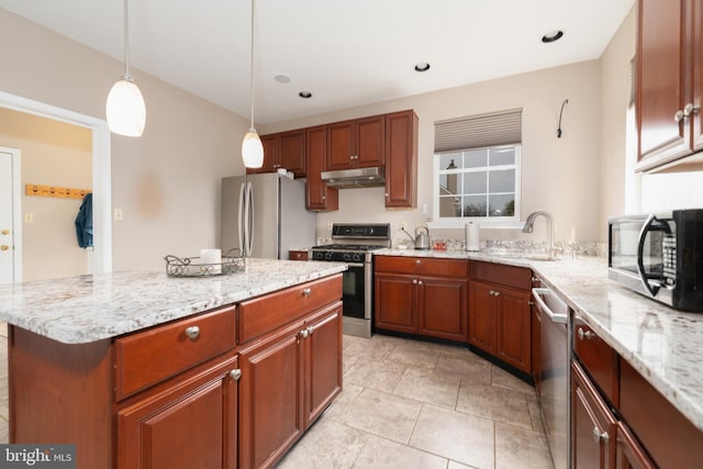 kitchen with light stone counters, a sink, hanging light fixtures, appliances with stainless steel finishes, and under cabinet range hood