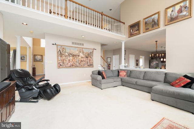 carpeted living room featuring recessed lighting, a towering ceiling, ornate columns, visible vents, and stairs