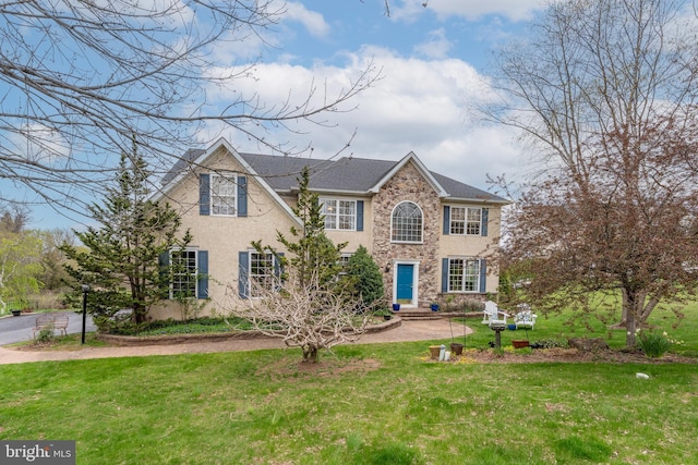 colonial-style house featuring stucco siding, a front lawn, and stone siding