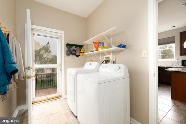 laundry area featuring baseboards, washer and clothes dryer, laundry area, and light tile patterned floors
