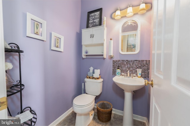 bathroom featuring toilet, a sink, and baseboards