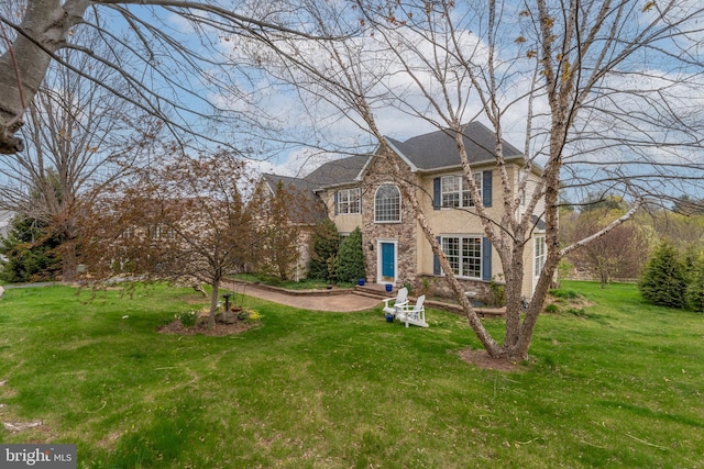 view of front of house featuring stucco siding, a front lawn, and stone siding