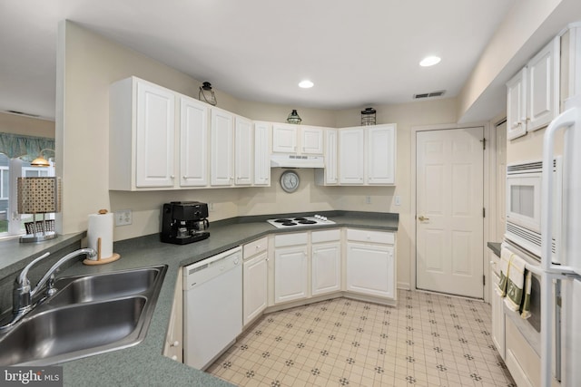 kitchen with under cabinet range hood, visible vents, a sink, white appliances, and white cabinetry