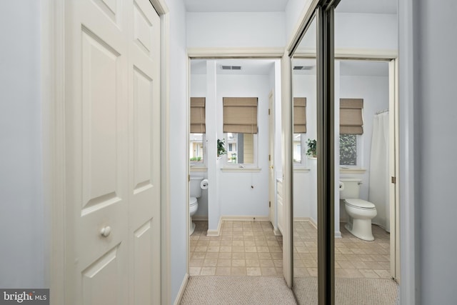 bathroom featuring tile patterned flooring, visible vents, toilet, and baseboards