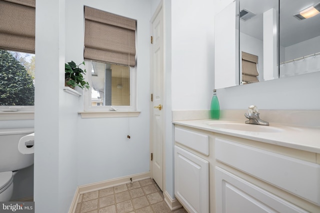 bathroom with tile patterned floors, vanity, baseboards, toilet, and visible vents