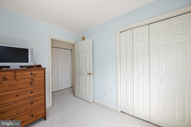 bedroom with light carpet, a closet, and baseboards