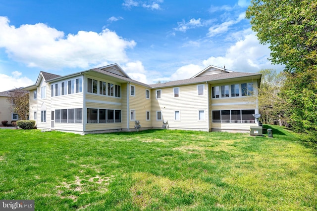 back of property featuring a lawn and cooling unit