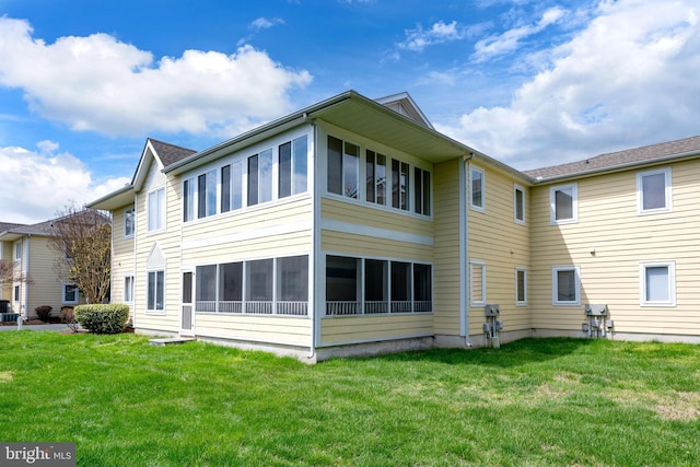rear view of house featuring a yard