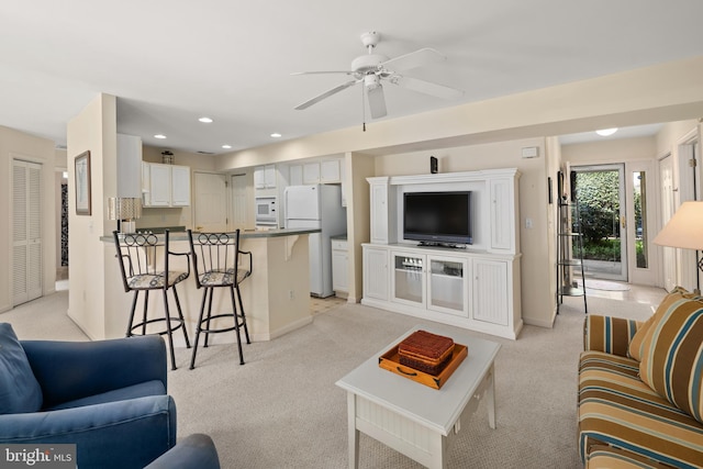 living room with ceiling fan, baseboards, recessed lighting, and light colored carpet