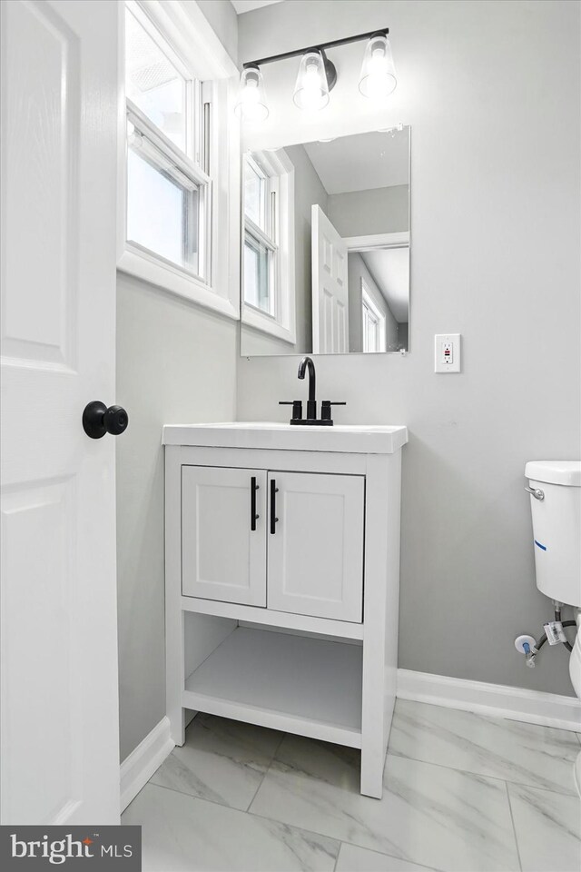 bathroom with vanity, marble finish floor, baseboards, and toilet