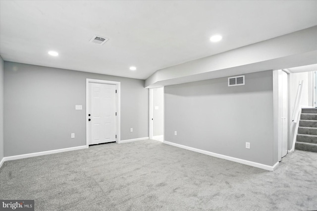 finished below grade area featuring carpet floors, stairs, visible vents, and recessed lighting