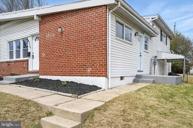 view of side of home featuring a lawn and brick siding