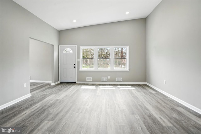 unfurnished living room featuring baseboards, wood finished floors, and visible vents
