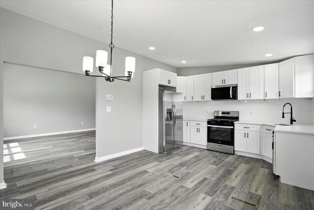 kitchen with light wood-style floors, an inviting chandelier, appliances with stainless steel finishes, and a sink