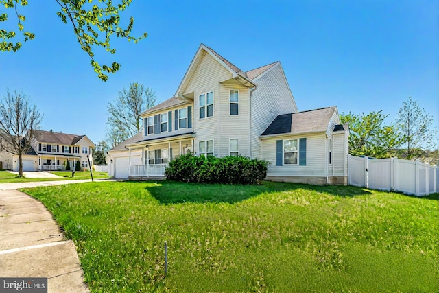exterior space with fence, a front yard, driveway, and an attached garage