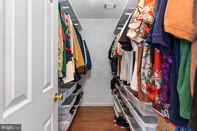 walk in closet with visible vents and wood finished floors