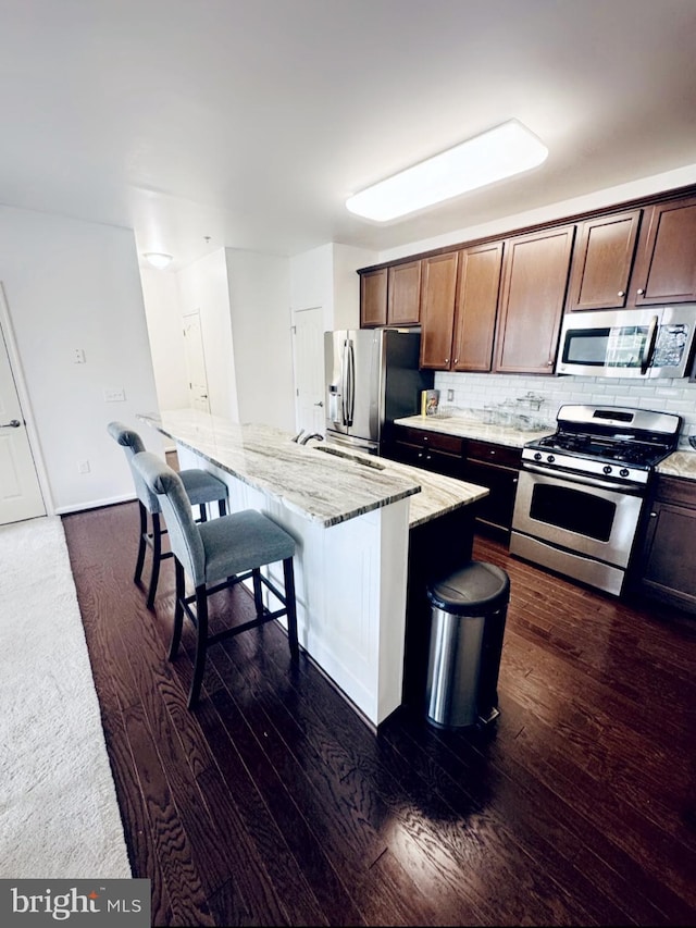 12 Canal Xing Unit 228, Burlington Township, NJ 08016 - kitchen featuring stainless steel appliances, light stone countertops, decorative backsplash, and a kitchen bar