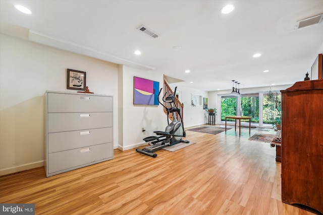 workout room featuring light wood-type flooring, visible vents, and baseboards