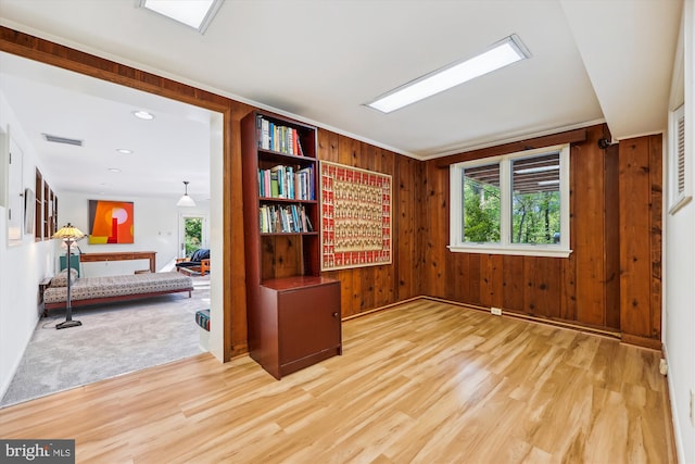 spare room featuring wooden walls, wood finished floors, and visible vents