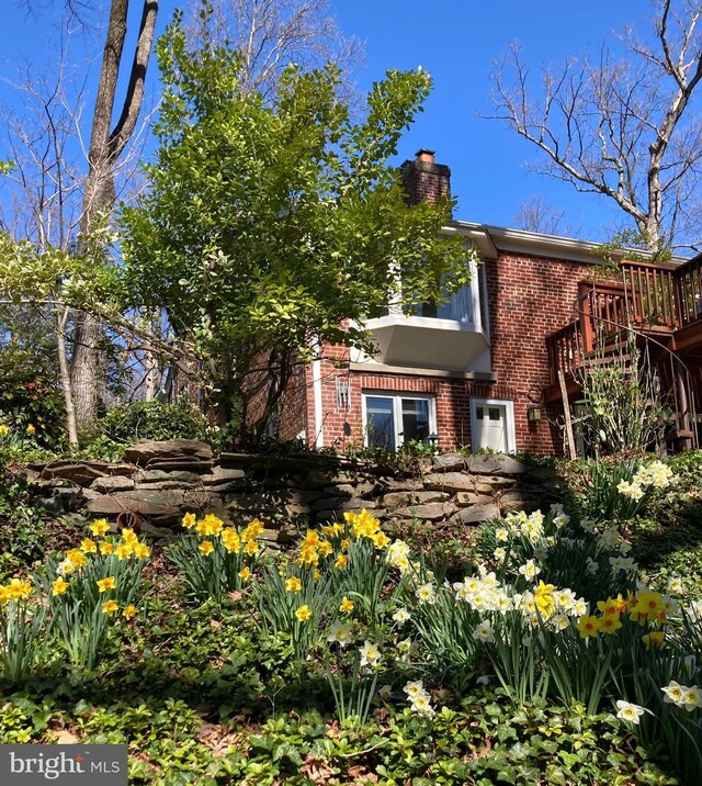 view of front facade featuring a chimney and brick siding