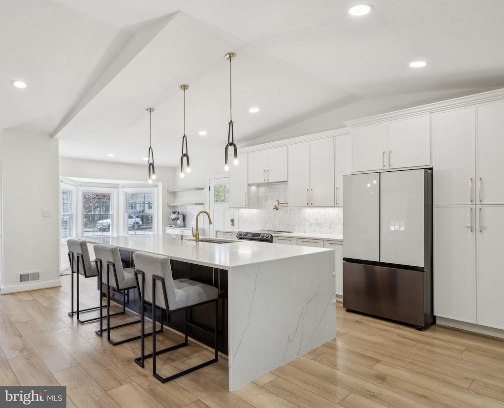 10012 Cotton Farm Rd, Fairfax, VA 22032 - kitchen featuring visible vents, freestanding refrigerator, white cabinetry, and an island with sink
