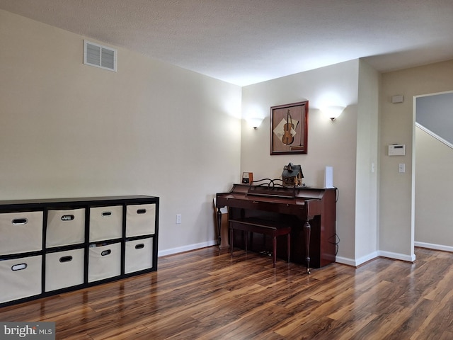 sitting room with baseboards, wood finished floors, and visible vents