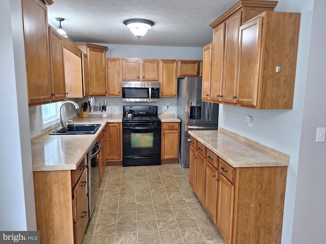 kitchen with light countertops, appliances with stainless steel finishes, brown cabinetry, and a sink