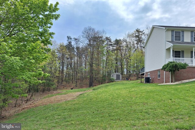 view of yard with a storage unit, central AC unit, and an outdoor structure