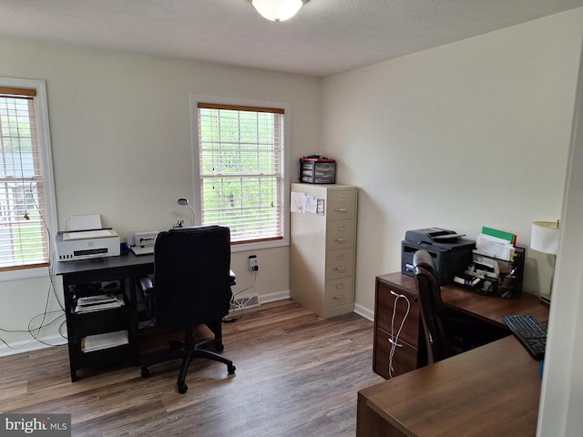 home office with baseboards and wood finished floors