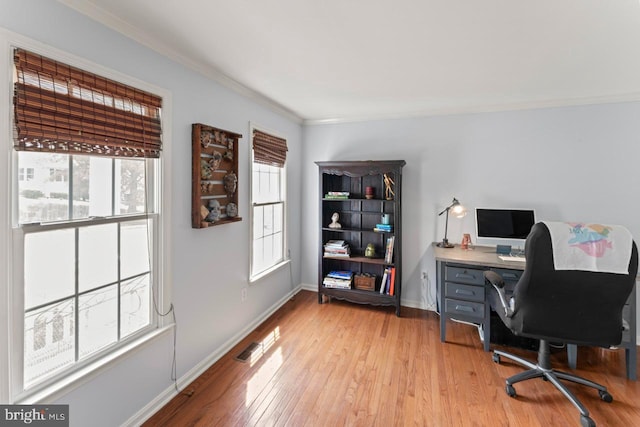 home office featuring baseboards, visible vents, ornamental molding, and light wood-style flooring