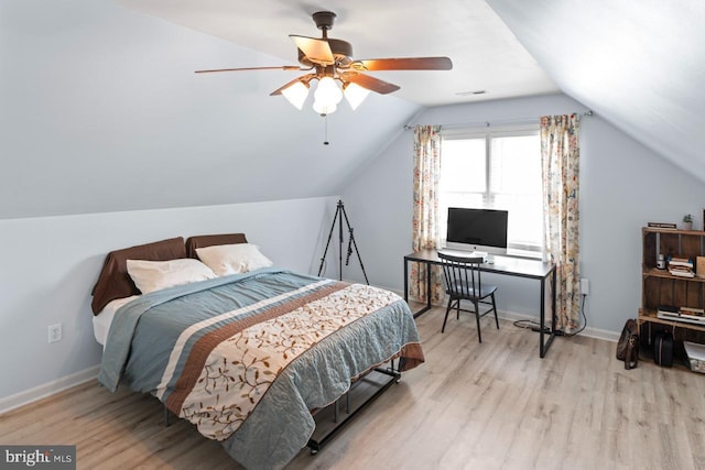 bedroom featuring visible vents, vaulted ceiling, wood finished floors, and baseboards