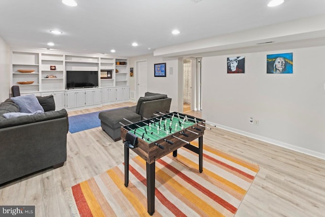 recreation room featuring baseboards, light wood-type flooring, and recessed lighting