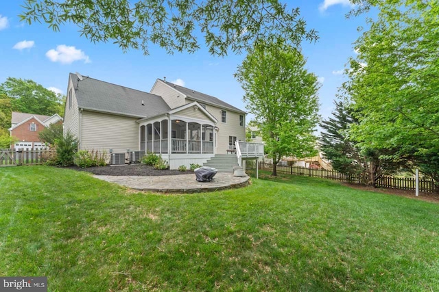 rear view of house featuring a sunroom, central air condition unit, a yard, and a fenced backyard