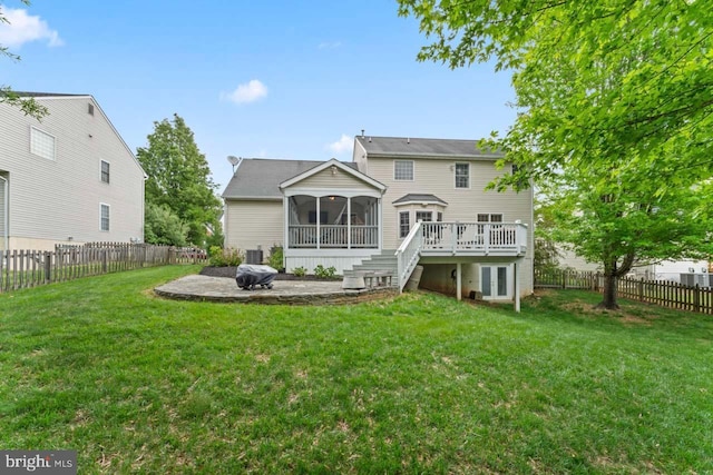 rear view of property featuring a yard, a sunroom, a patio, and a fenced backyard