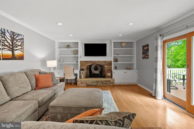 living area featuring light wood-style floors, built in shelves, ornamental molding, and recessed lighting