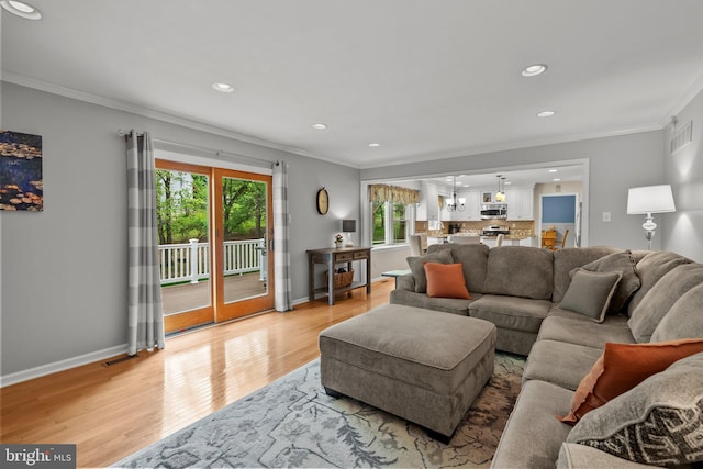 living area featuring crown molding, light wood-type flooring, baseboards, and recessed lighting