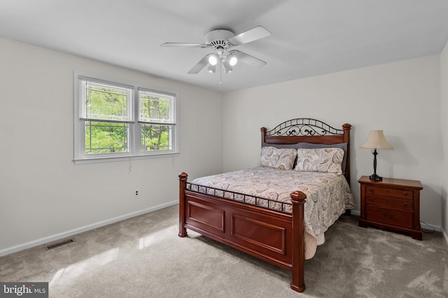 bedroom featuring light colored carpet, baseboards, ceiling fan, and visible vents