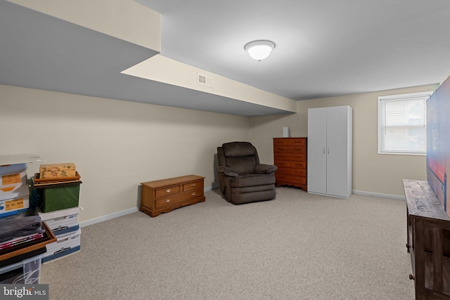 living area featuring baseboards, visible vents, and carpet
