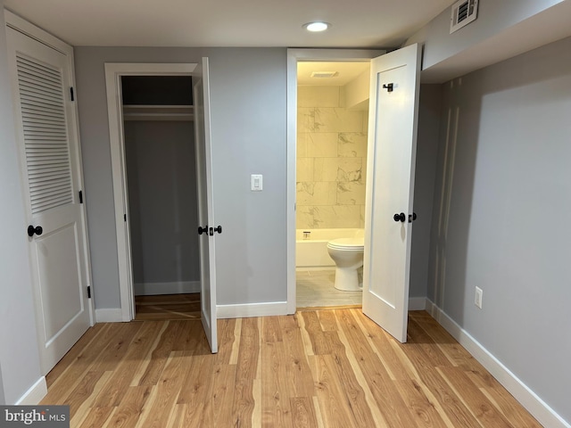 unfurnished bedroom with visible vents, light wood-type flooring, baseboards, connected bathroom, and recessed lighting